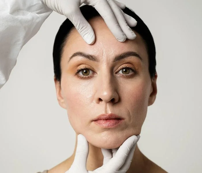Examining face of a girl for Botox injections.